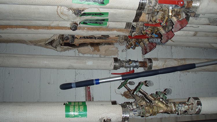 <p data-block-key="1wiow">Kuvan putkieristeissä esiintyy asbestia. Näyte otettiin linjasaneerausta varten tehdyssä haitta-ainekartoituksessa. Kuva: Kt-kuntotutkimus.</p>