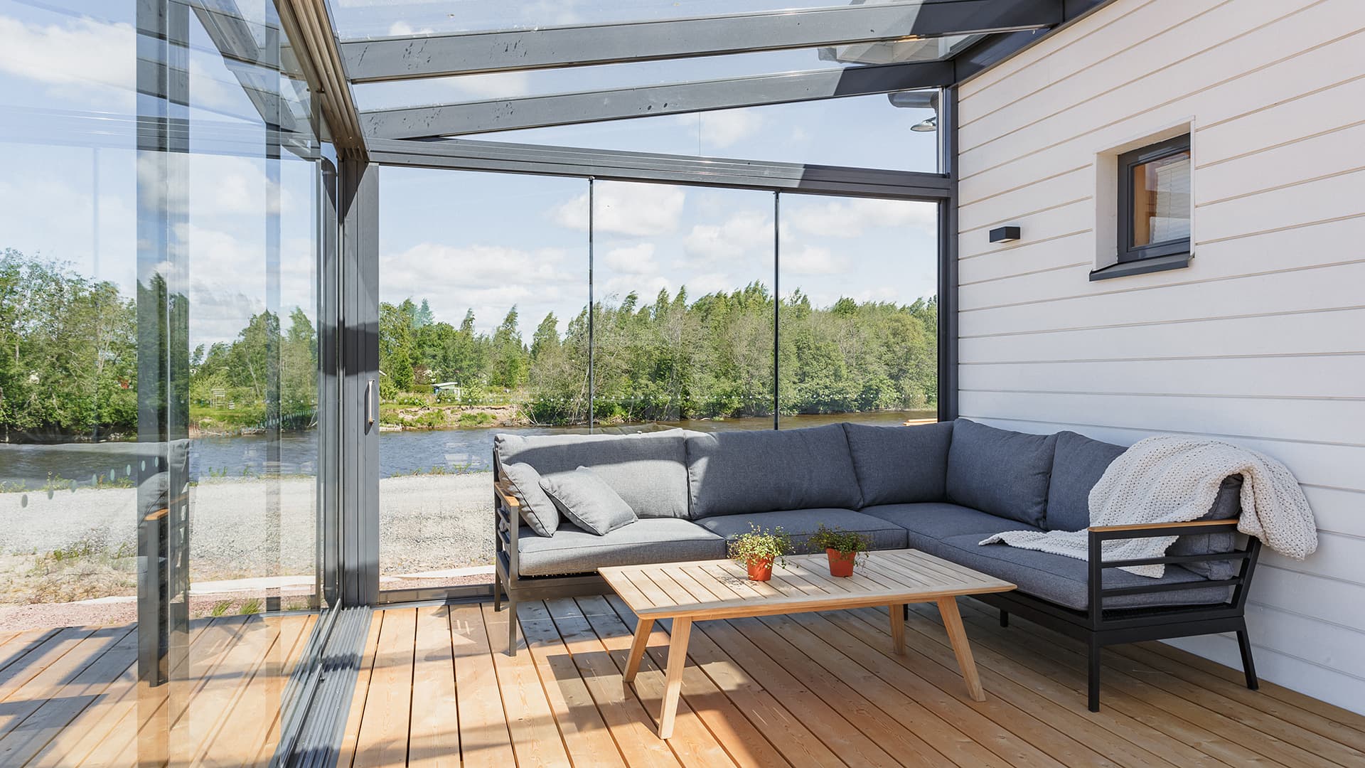 Lasiterassi jokinäkymällä